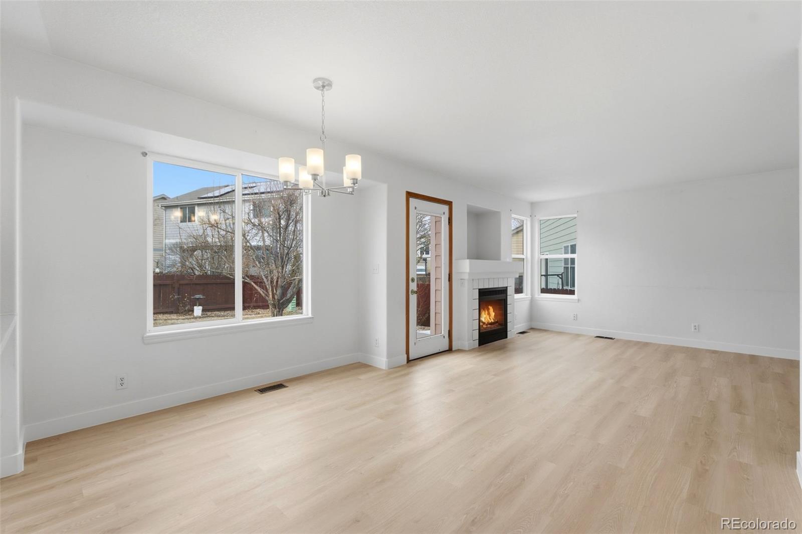 10505 Madison Way Northglenn, CO 80233 - Photo 14 of 49 an empty room with windows and chandelier fan