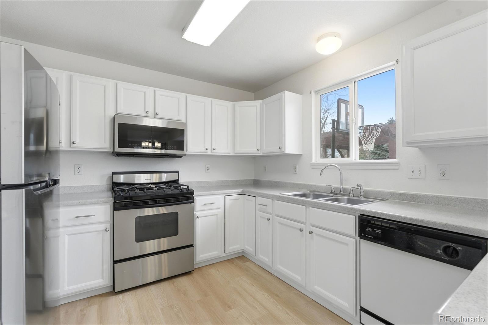 10505 Madison Way Northglenn, CO 80233 - Photo 16 of 49 a kitchen with cabinets stainless steel appliances a sink and a stove