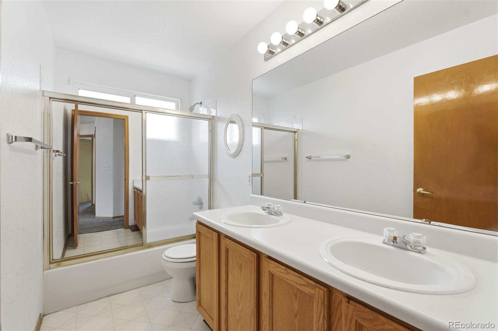 10505 Madison Way Northglenn, CO 80233 - Photo 33 of 49 a bathroom with a double vanity sink toilet mirror and shower