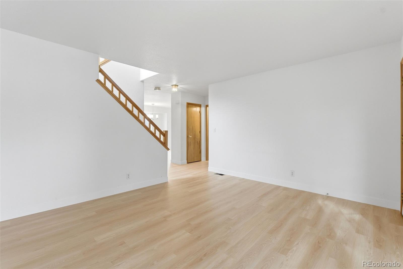 10505 Madison Way Northglenn, CO 80233 - Photo 4 of 49 a view of an empty room with wooden floor