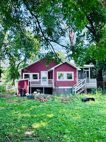 a front view of a house with a yard and trees