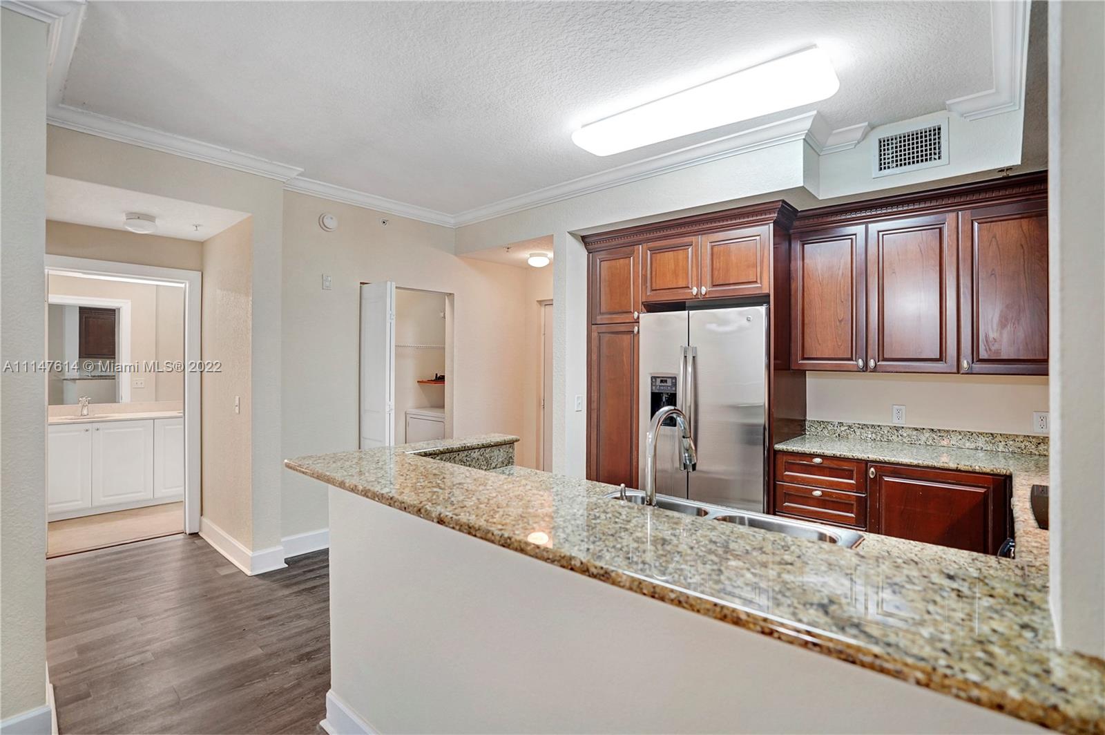 1660 Renaissance Commons Boulevard, Unit 2203 Boynton Beach, FL 33426 - Photo 1 of 20 a kitchen with stainless steel appliances granite countertop a sink refrigerator and cabinets
