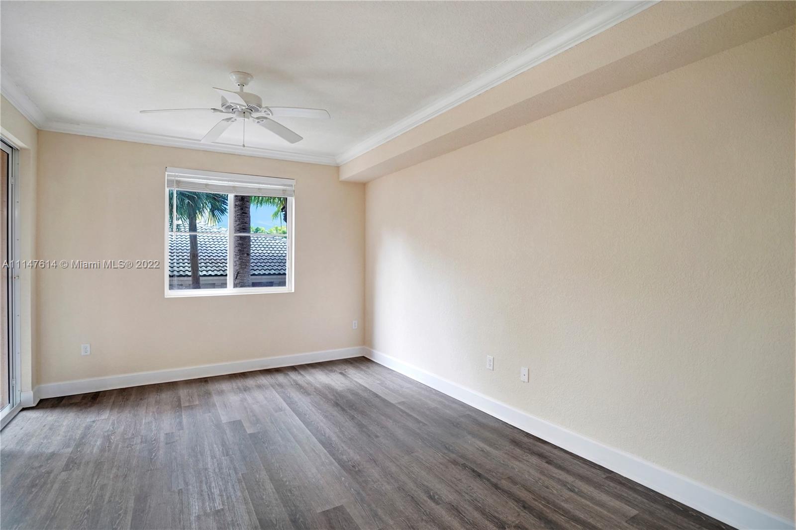 1660 Renaissance Commons Boulevard, Unit 2203 Boynton Beach, FL 33426 - Photo 12 of 20 a view of an empty room with wooden floor and a window