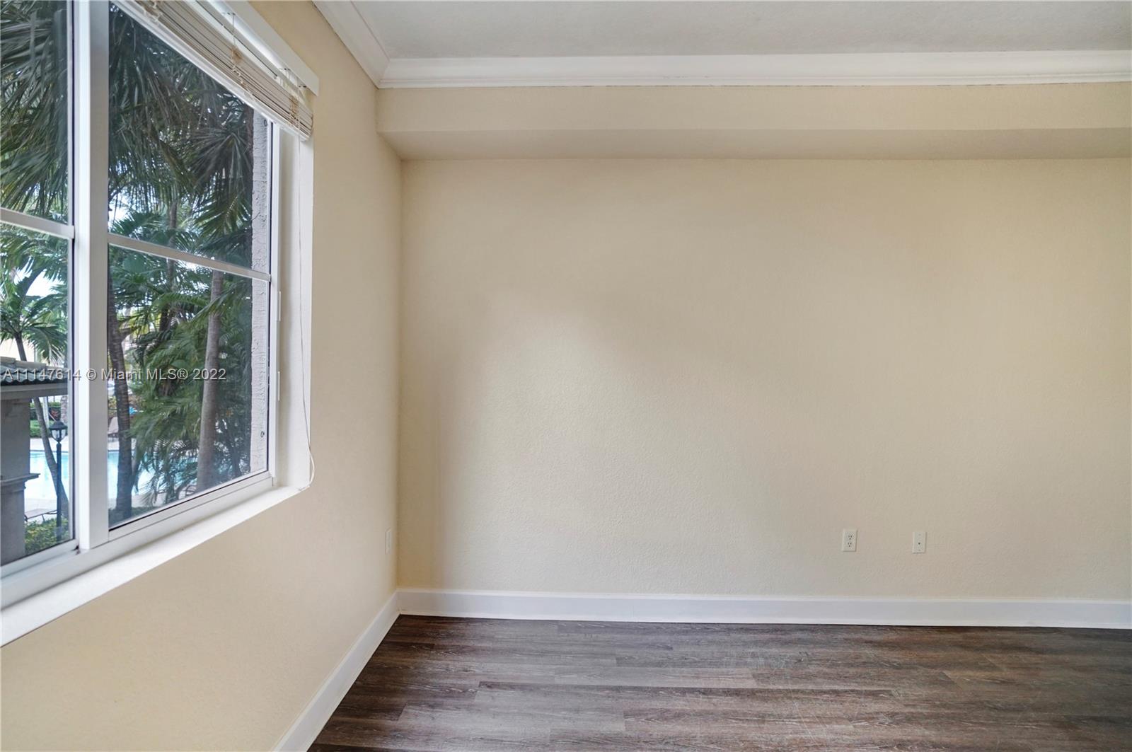 1660 Renaissance Commons Boulevard, Unit 2203 Boynton Beach, FL 33426 - Photo 14 of 20 a view of an empty room with wooden floor and a window