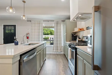 a kitchen with stainless steel appliances granite countertop a sink and a stove