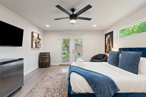 a bedroom with a bed a couch and a flat screen tv