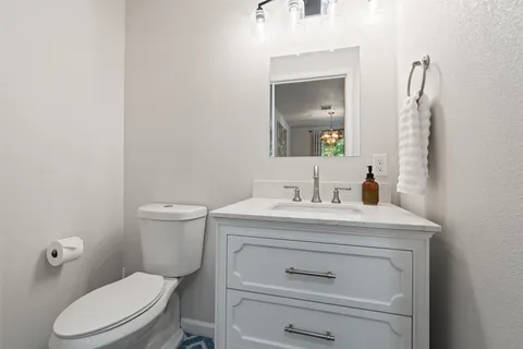 a bathroom with a toilet a sink and mirror