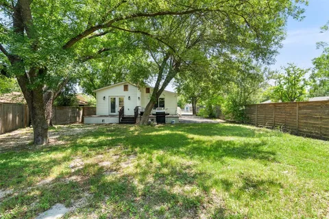 a view of a house with backyard and a tree