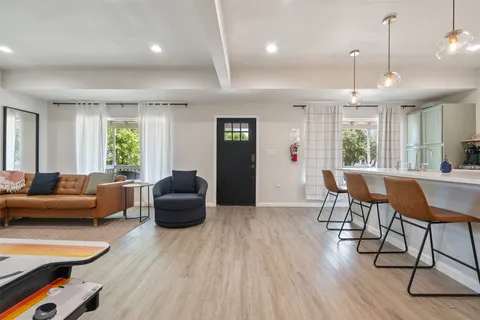a living room with furniture a wooden floor and a large window