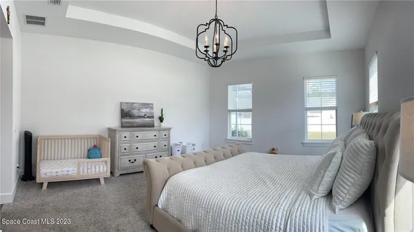 a bedroom with a bed and a chandelier