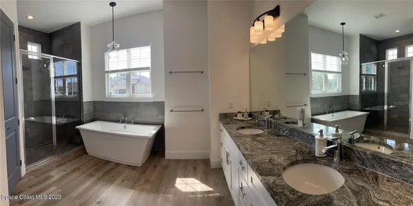 a bathroom with a granite countertop sink mirror and tub
