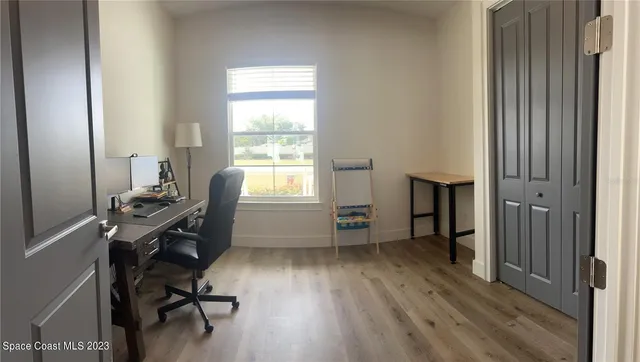 a view of a workspace with furniture and a window