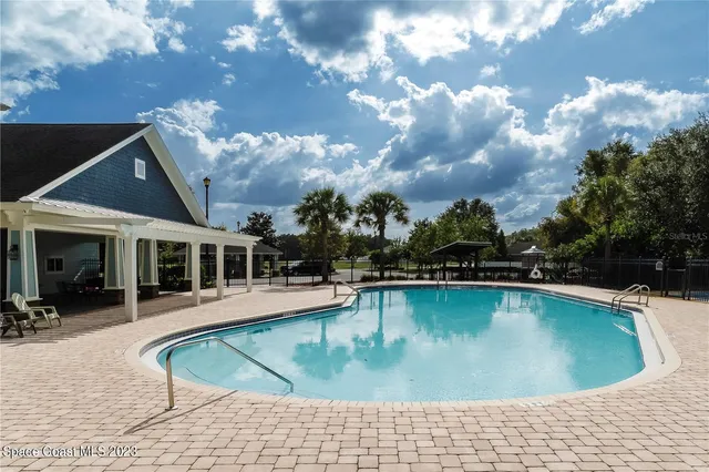 a view of a house with swimming pool and sitting area
