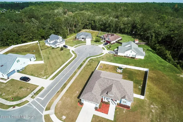 an aerial view of a house with swimming pool and lake view