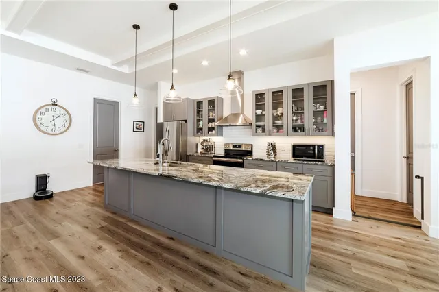 a kitchen with stainless steel appliances granite countertop a sink and a refrigerator