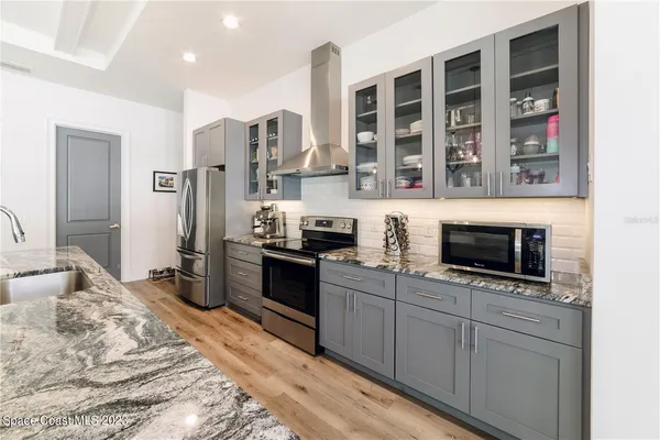 a kitchen with stainless steel appliances granite countertop a stove a sink and a microwave