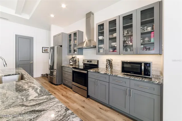 a kitchen with stainless steel appliances granite countertop a stove a sink and a microwave