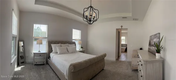 a bedroom with a bed and a chandelier