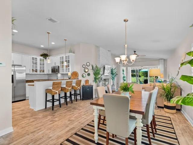 a dining room filled chandelier and wooden floor