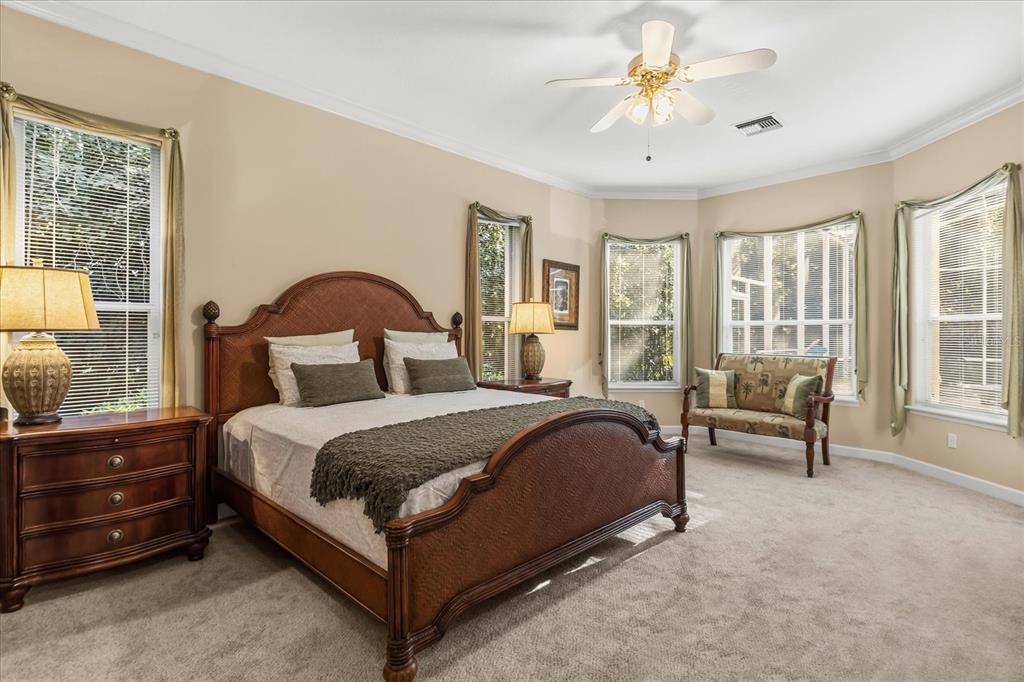 693 Stonefield Loop Lake Mary, FL 32746 - Photo 14 of 40 a spacious bedroom with a bed and a couch next to a window