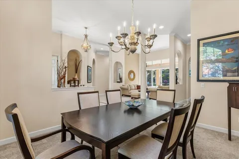 a view of a dining room with furniture a chandelier and wooden floor