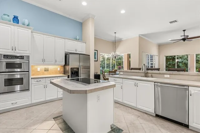 a kitchen with cabinets appliances a sink and a counter top space