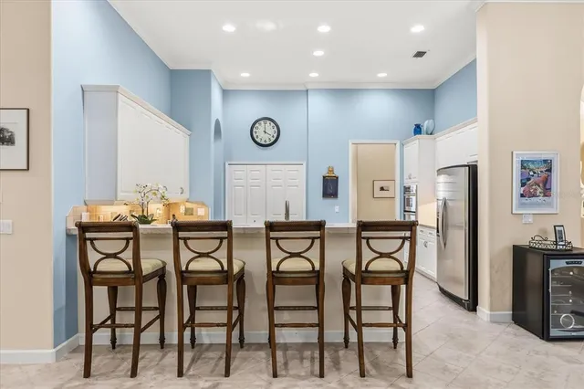 a kitchen with stainless steel appliances a dining table chairs and refrigerator