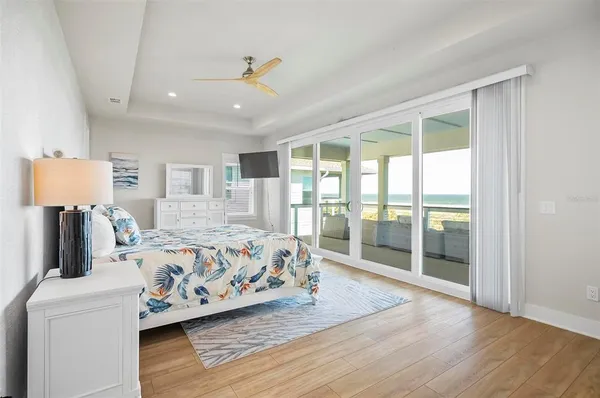 a bedroom with a bed and a large window with wooden floor