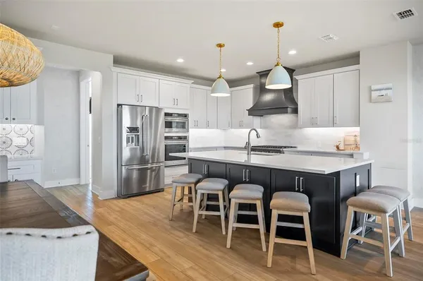 a kitchen with stainless steel appliances a stove a sink island and a refrigerator