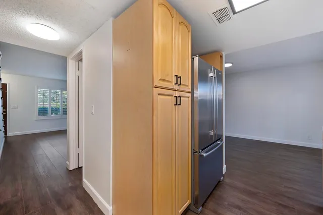 a kitchen with a refrigerator sink and cabinets