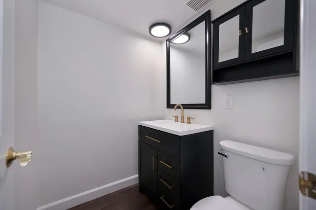 a kitchen with stainless steel appliances granite countertop a sink a stove cabinets and wooden floor