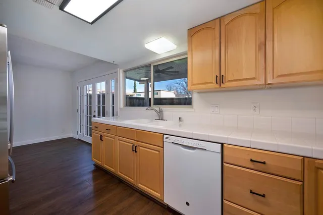 an empty room with wooden floor mirror and windows