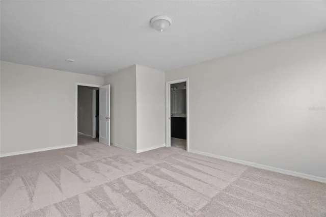 a view of an empty room with closet and a window