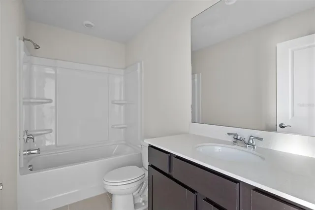 a bathroom with a granite countertop sink a toilet and shower