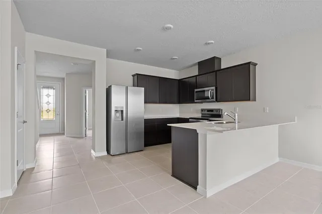 a kitchen with stainless steel appliances granite countertop a refrigerator and a stove top oven