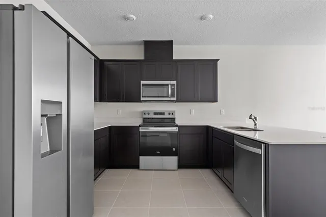 a kitchen with stainless steel appliances granite countertop a refrigerator and a stove top oven