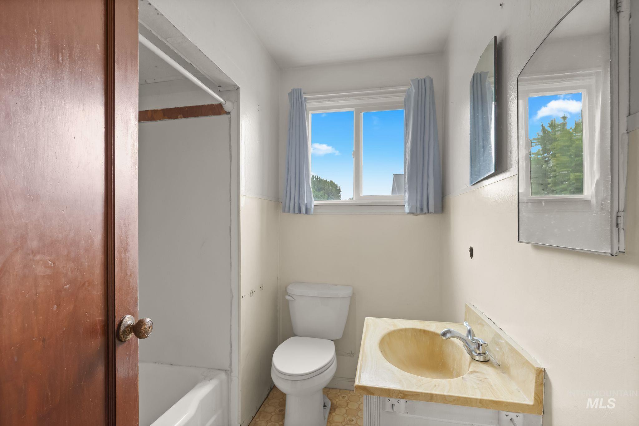 2255 Appleside Boulevard Clarkston, WA 99403 - Photo 18 of 41 Bathroom area featuring a vanity with an integrated sink, dual wall-mounted mirrors, and a white wall finish