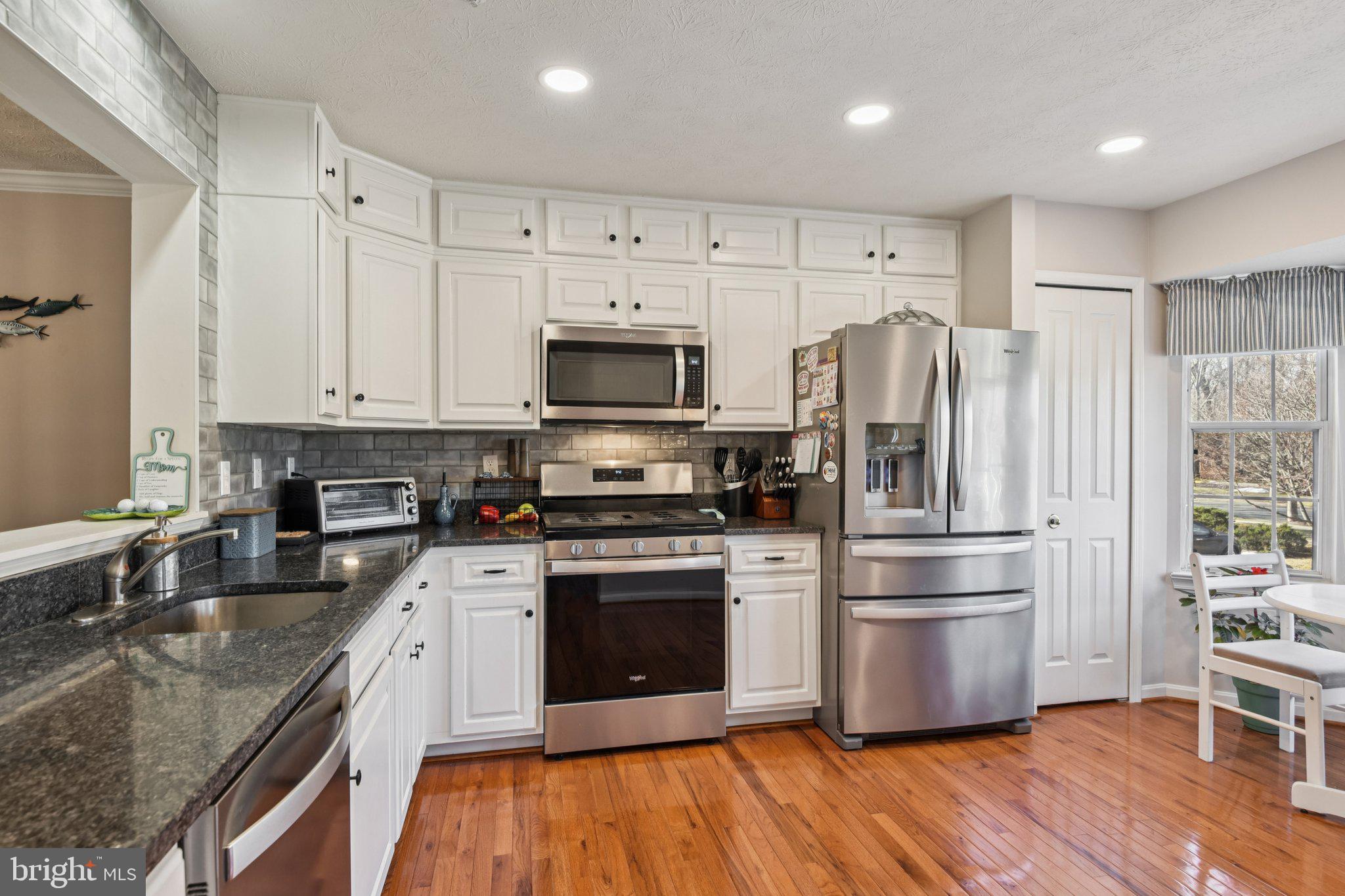 2612 Tallwind Court Crofton, MD 21054 - Photo 12 of 38 a kitchen with kitchen island granite countertop a sink cabinets and stainless steel appliances