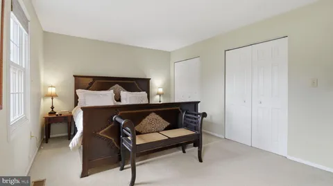 a bedroom with bed a lamp and a window