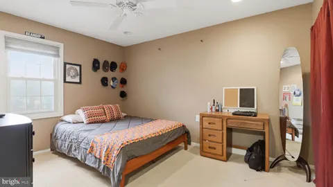 a bedroom with a bed and a flat tv screen on a dresser