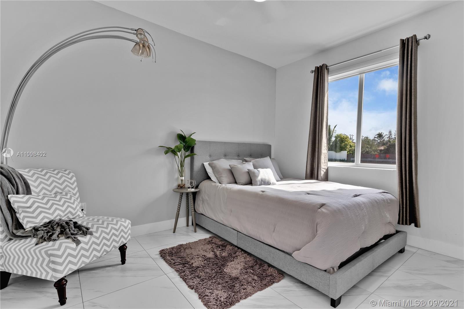 18334 Southwest 139th Path Miami, FL 33177 - Photo 27 of 62 a bed sitting in a bedroom next to a window