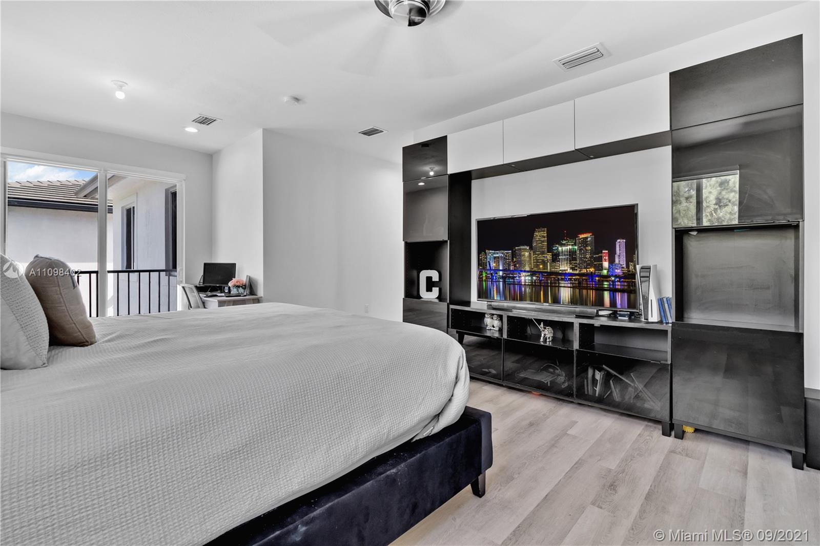 18334 Southwest 139th Path Miami, FL 33177 - Photo 9 of 62 a bedroom with a bed and a flat tv screen on wall