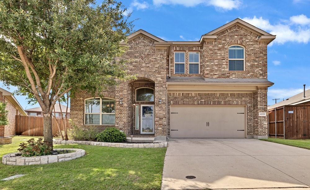 a front view of a house with a garden and yard