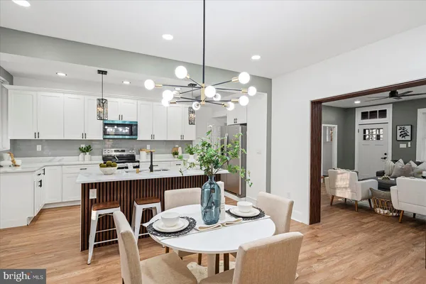 a kitchen with kitchen island a dining table chairs and wooden floor