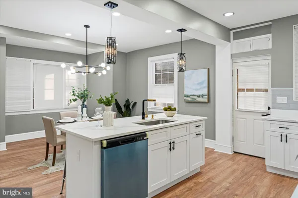 a kitchen with a sink stove and wooden floor