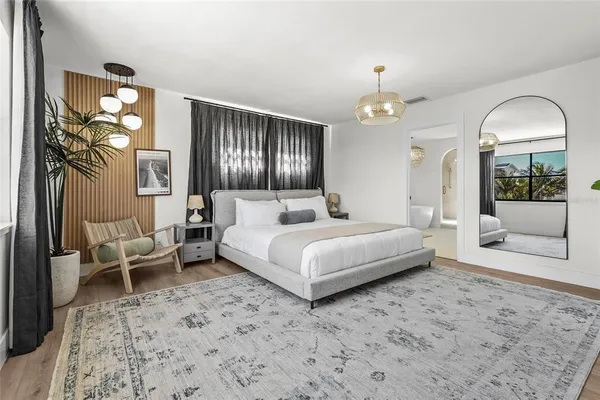 a bedroom with a bed and a chandelier