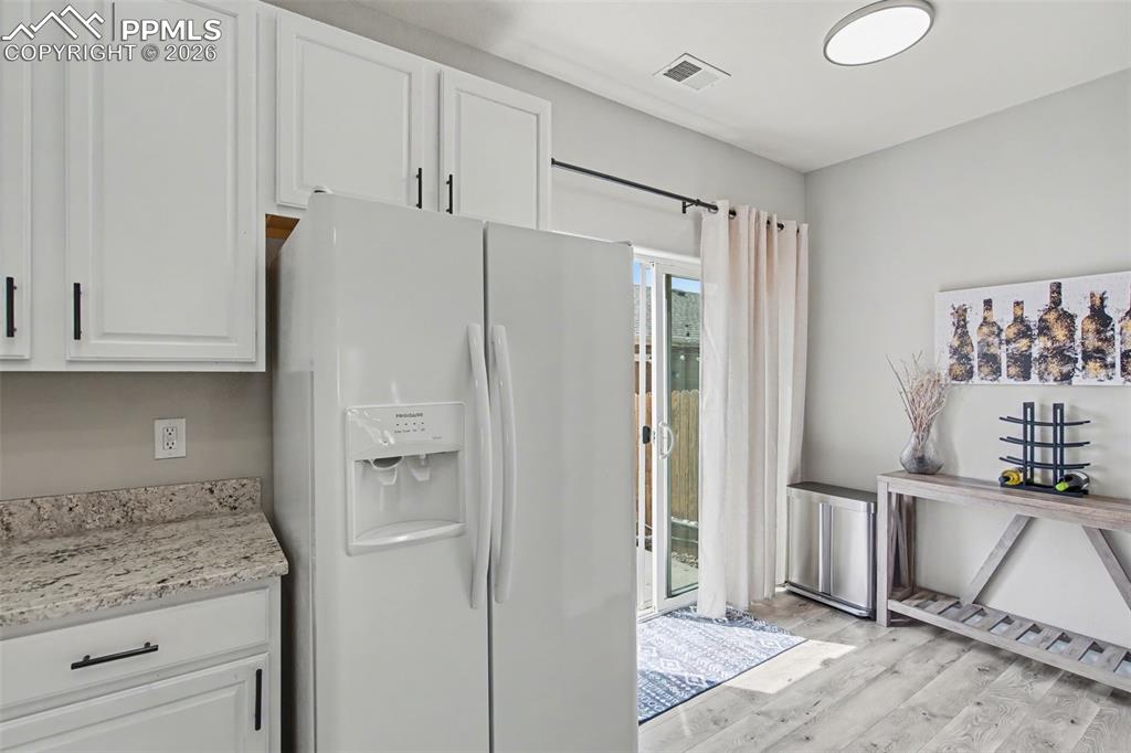 4833 Harrier Ridge Drive Colorado Springs, CO 80916 - Photo 12 of 25 a kitchen with a refrigerator and cabinets