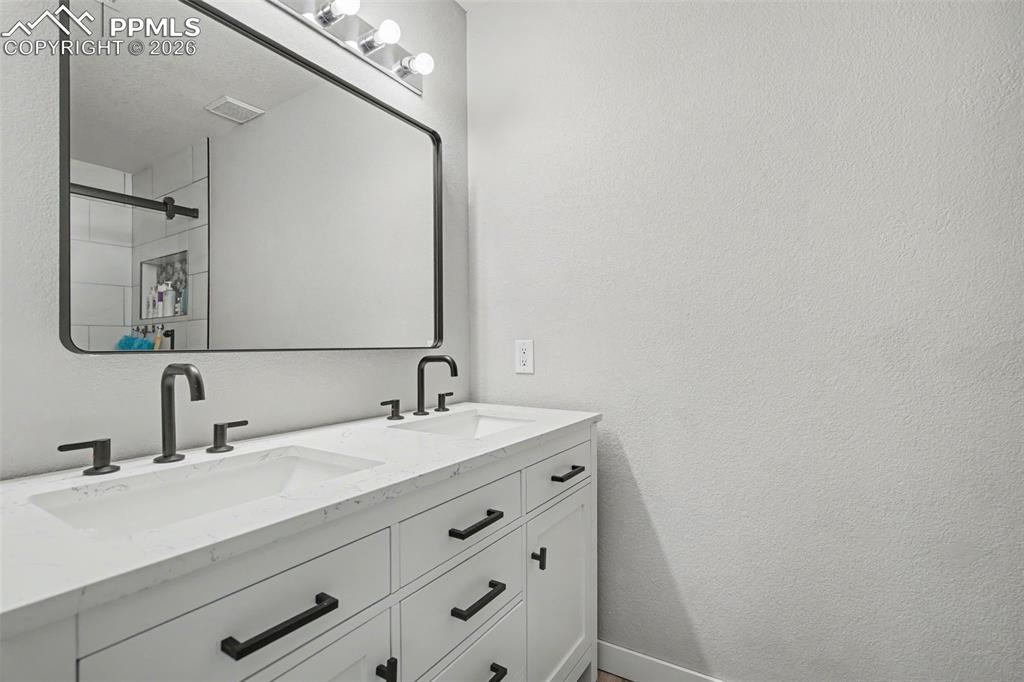4833 Harrier Ridge Drive Colorado Springs, CO 80916 - Photo 19 of 25 a bathroom with a sink and a mirror