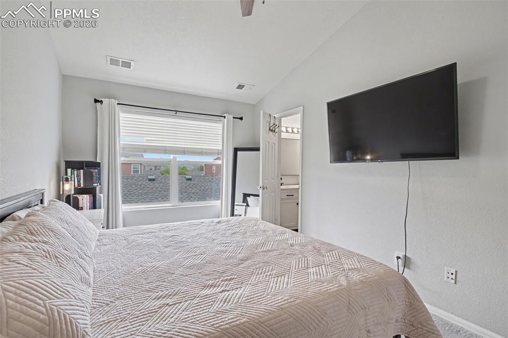 4833 Harrier Ridge Drive Colorado Springs, CO 80916 - Photo 20 of 25 a bedroom with a bed and a flat screen tv