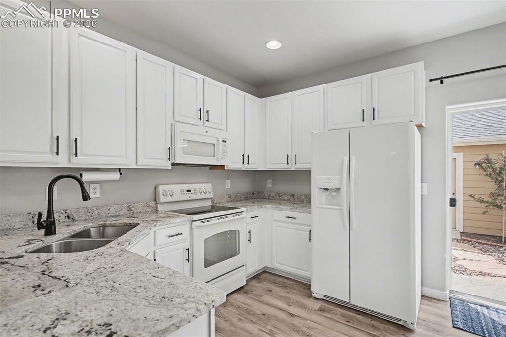4833 Harrier Ridge Drive Colorado Springs, CO 80916 - Photo 10 of 25 a kitchen with stainless steel appliances granite countertop a sink stove and refrigerator